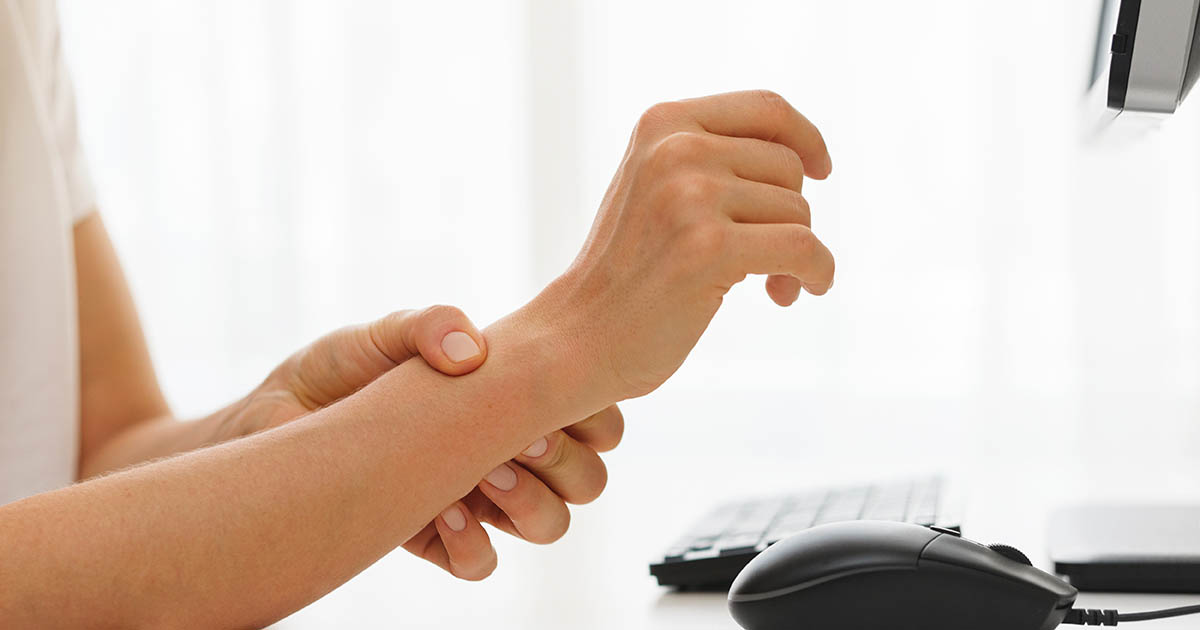 Close-up of a hand and wrist being examined for carpal tunnel syndrome at Spine and Wellness Center Lakewood Ranch, with the median nerve path through the wrist highlighted